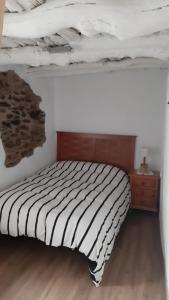 1 dormitorio con 1 cama y suelo de madera en Casa Rocio, en Capileira