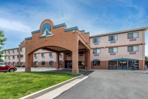 a hotel with a large building with a parking lot at Comfort Inn & Suites in Fruita