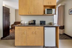 a kitchen with wooden cabinets and a white refrigerator at Comfort Inn & Suites Fruita - Grand Junction in Fruita