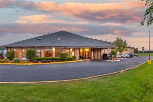 un gran edificio con aparcamiento en Rodeway Inn Coopersville en Coopersville