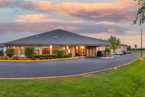 a large building with a parking lot at Rodeway Inn Coopersville in Coopersville