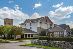 a large white building with a stone wall at Comfort Inn in Preston