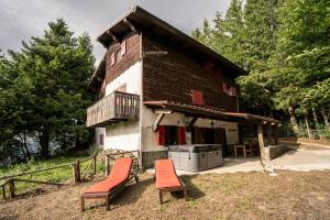 a house with two chairs in front of it at Casa Lampo in Abetone