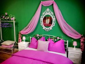Dormitorio verde con cama con almohadas rosas en Lighane's Studio with Sailor Moon Room, en Núremberg