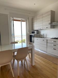 een keuken met een tafel en stoelen in een kamer bij La vista sul porto in Marina di Ragusa