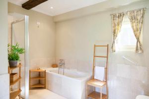 bagno con vasca, doccia e lavandino di RATAFIÀ Appartamento con vista sul lago a Orta San Giulio