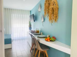 um quarto azul com uma mesa com fruta em Batata - Estúdios em Nazaré