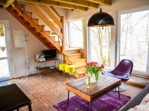 uma sala de estar com mesa, cadeiras e escadas em tuŻur domki nad potokiem em Osie