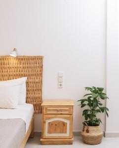 a bedroom with a bed and a nightstand with a plant at Amalia in Matala