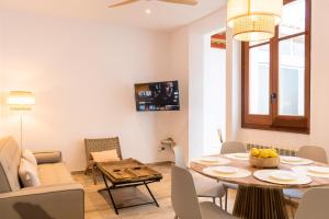 ein Wohnzimmer mit einem Tisch und einem Sofa in der Unterkunft Apartamento mediterraneo, nuevo y acogedor de Eva in Sant Feliu de Guixols