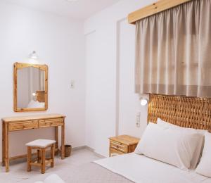 a bedroom with a bed and a mirror and a table at Amalia in Matala