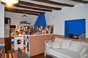a living room with a white couch and a kitchen at Casa Rural Los Lilos in Gotor