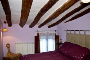 a bedroom with a purple bed and a window at Casa Rural Los Lilos in Gotor