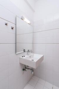 a white bathroom with a sink and a mirror at Amalia in Matala