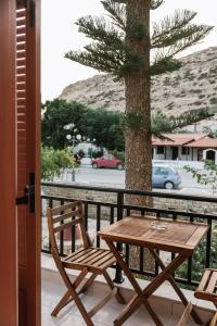 a table and chairs on a balcony with a tree at Amalia in Matala