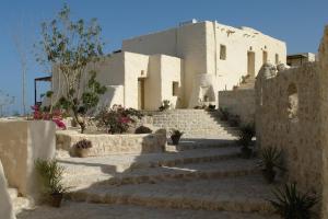 - un bâtiment blanc avec des escaliers devant dans l'établissement The Oasis, à Abu Dabab