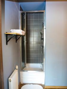 um chuveiro com uma porta de vidro na casa de banho em Willa tuŻur em Osie