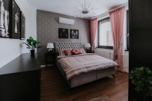 um quarto com uma cama e uma janela com cortinas cor-de-rosa em Apartmány Evia clinic em Levice