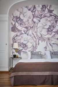 a bedroom with a mural of flowers on the wall at Hotel Monopol - Central Station in Frankfurt/Main