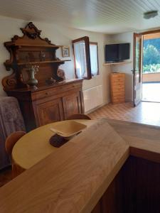 uma sala de estar com uma mesa de madeira e uma televisão em Le chant de la rivière em Le Massot