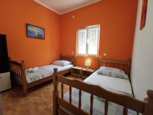 two beds in a room with orange walls at Apartments Montenegrina in Ulcinj