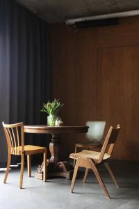 a wooden table with a chair and a plant at Guesthouse Kalkbreite in Zurich