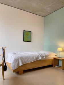 a bedroom with a bed, desk, and lamp at Guesthouse Kalkbreite in Zurich