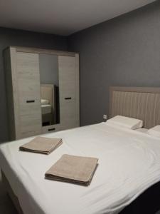 a bedroom with a white bed with two towels on it at Ultraviolet relax apart in Sofia