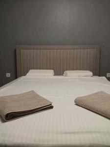 a white bed with two towels on top of it at Ultraviolet relax apart in Sofia