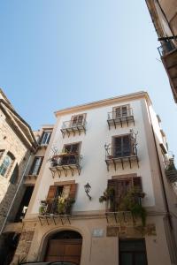 un edificio blanco con balcones y plantas. en Casa Miqvà - Rooms in shared apartment, en Palermo