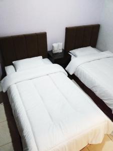 dos camas sentadas una al lado de la otra en una habitación en BLESSING RESIDENCE HOTEL, en Yakarta