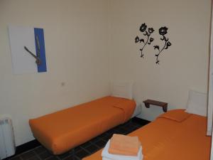 two beds in a room with a clock on the wall at Fonda Can Fasersia in La Pobla de Segur