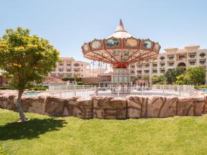 un giro sulle montagne russe in un parco di fronte a un edificio di Serenity Alma Heights - Ex Serenity Fun City a Hurghada