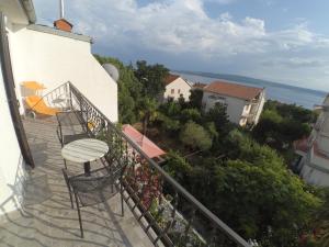 a balcony with a table and chairs on a building at Dramalj apartman 4+1 in Dramalj