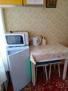 TyrnyauzにあるApartment v Prielbrusyeの小さなテーブル(冷蔵庫上に電子レンジ付)