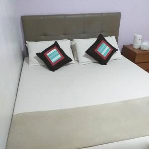 a white bed with two pillows on top of it at BLESSING RESIDENCE HOTEL in Jakarta