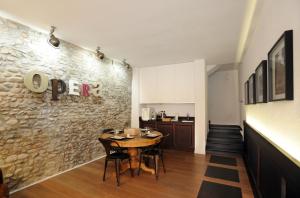 una sala da pranzo con tavolo e parete in pietra di Opera 11 r&b a Parma