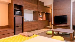 Hotel Sunset Hill في أونا: غرفة مع مطبخ مع تلفزيون وطاولة