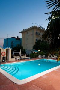 a large swimming pool in front of a building at Hotel Gaudia in Riccione