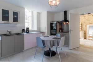 cocina con mesa y sillas en una habitación en Le Gîte de Mélie, en Pommard