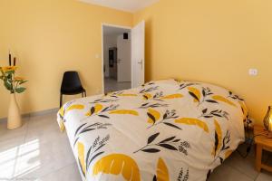 1 dormitorio con 1 cama con edredón naranja y blanco en Le Gîte de Mélie, en Pommard