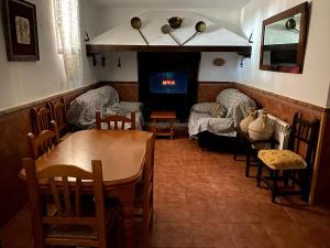 ein Esszimmer mit einem Tisch, Stühlen und einem Kamin in der Unterkunft Casa Rural Arados in Priego de Córdoba