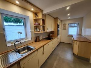 eine große Küche mit einem Waschbecken und einem Fenster in der Unterkunft Haus Chiara in Bad Kissingen