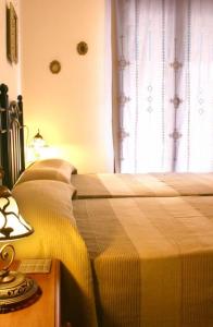 2 camas individuales en un dormitorio con ventana en Casa Rural Arados, en Priego de Córdoba