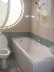 łazienka z białą wanną i toaletą w obiekcie Marina House w mieście Sulina