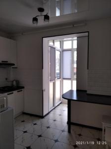 una cocina con una puerta abierta a una cocina con una mesa en Ukrainska Apartment, en Irpín