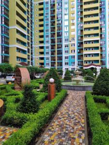 Un jardín frente a unos edificios altos. en Ukrainska Apartment, en Irpín