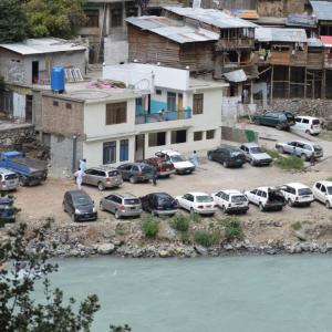 a group of cars parked in a parking lot next to a river at Zahoor Hotel And Restaurant in Barāniā