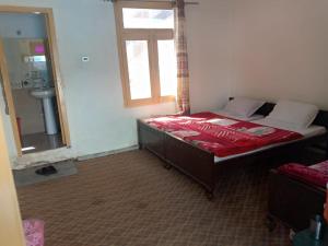 um quarto com uma cama, uma janela e um espelho em Zahoor Hotel And Restaurant em Barāniā