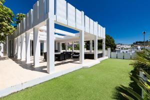 an external view of a white building with grass at Villa Flamingos Marbella in Marbella